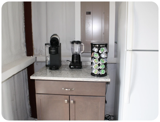 A kitchen with two coffee makers and a blender.