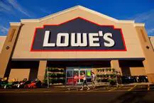 A lowe 's store with people walking in front of it.