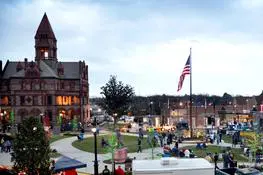 A view of people in the park and an american flag.