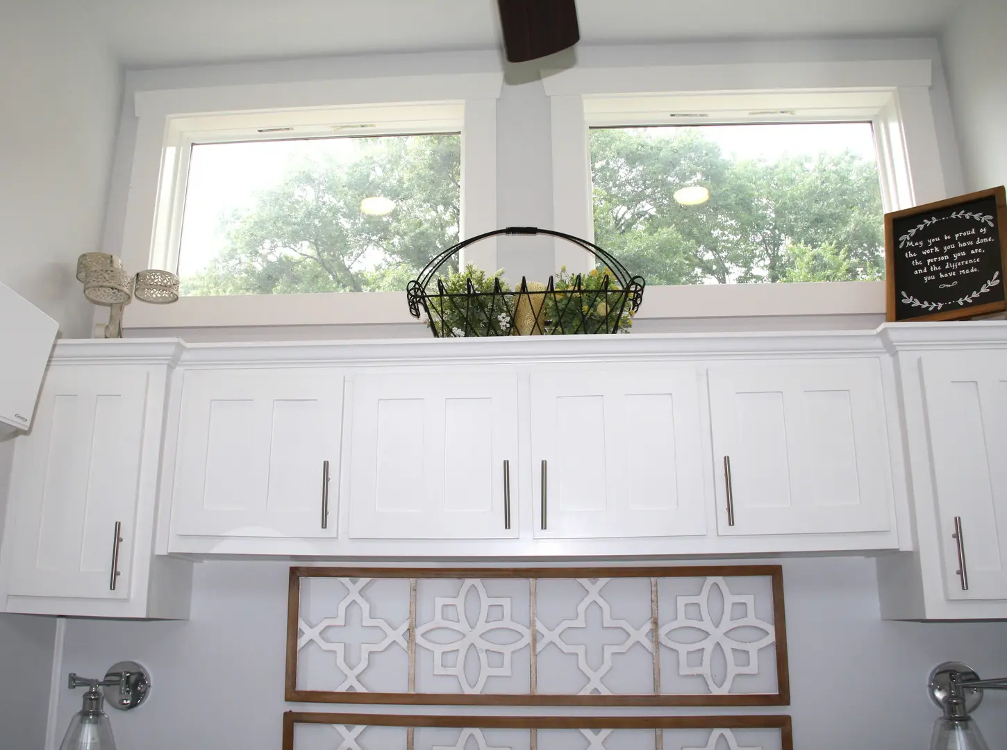 A kitchen with white cabinets and a window.