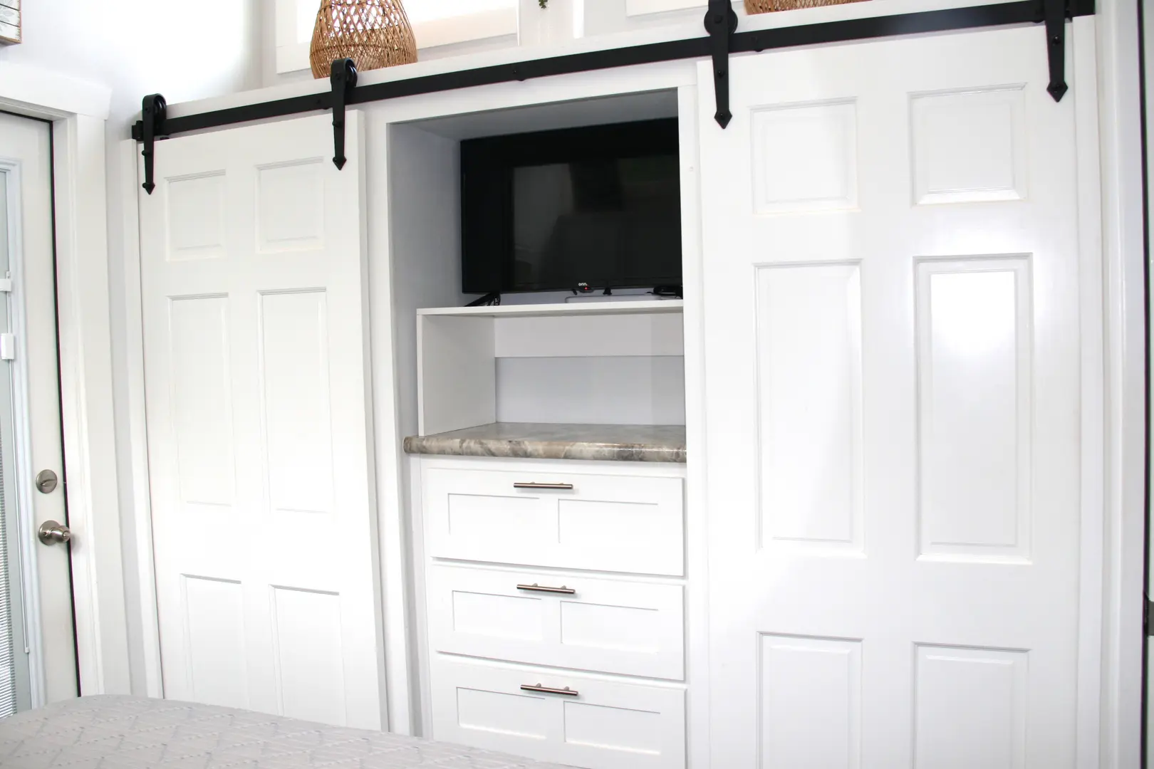 A closet with sliding doors and a tv in it.