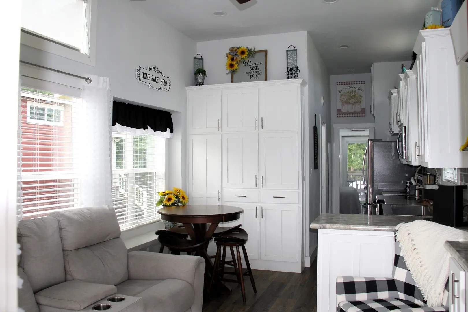 A living room with white walls and black furniture.