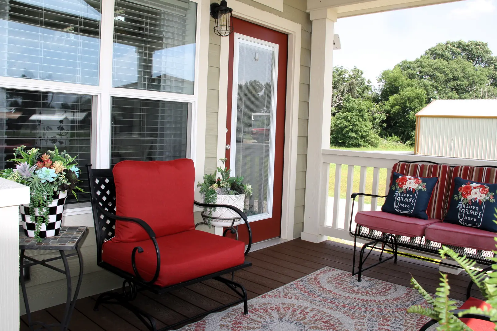 A porch with two chairs and a table.