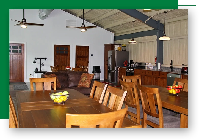 A large room with wooden furniture and green pillows.