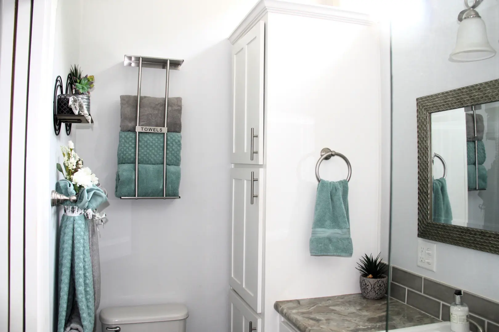 A bathroom with a toilet, sink and mirror.