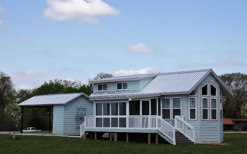 A house with a porch and a deck in the front yard.