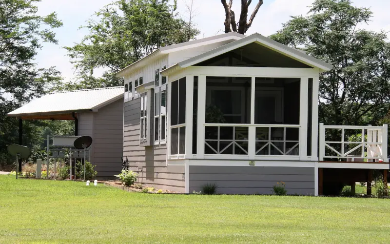 A small house with a porch and windows.