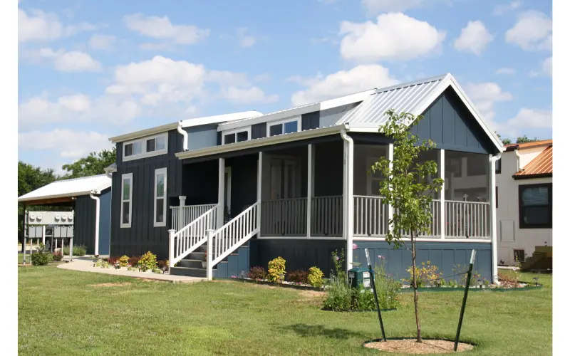 A house with a porch and stairs in front of it.