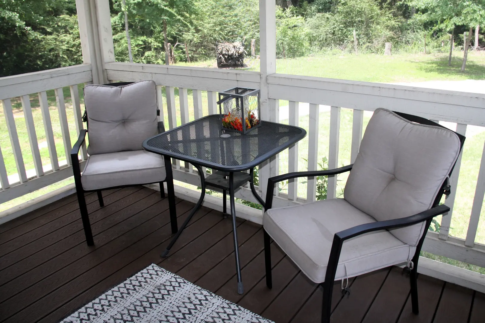 A table and two chairs on the porch.