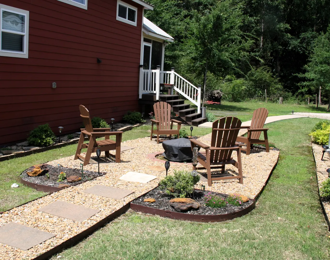 A patio with chairs and fire pit in the middle of it.