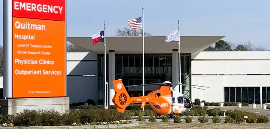 A helicopter sculpture in front of an office building.