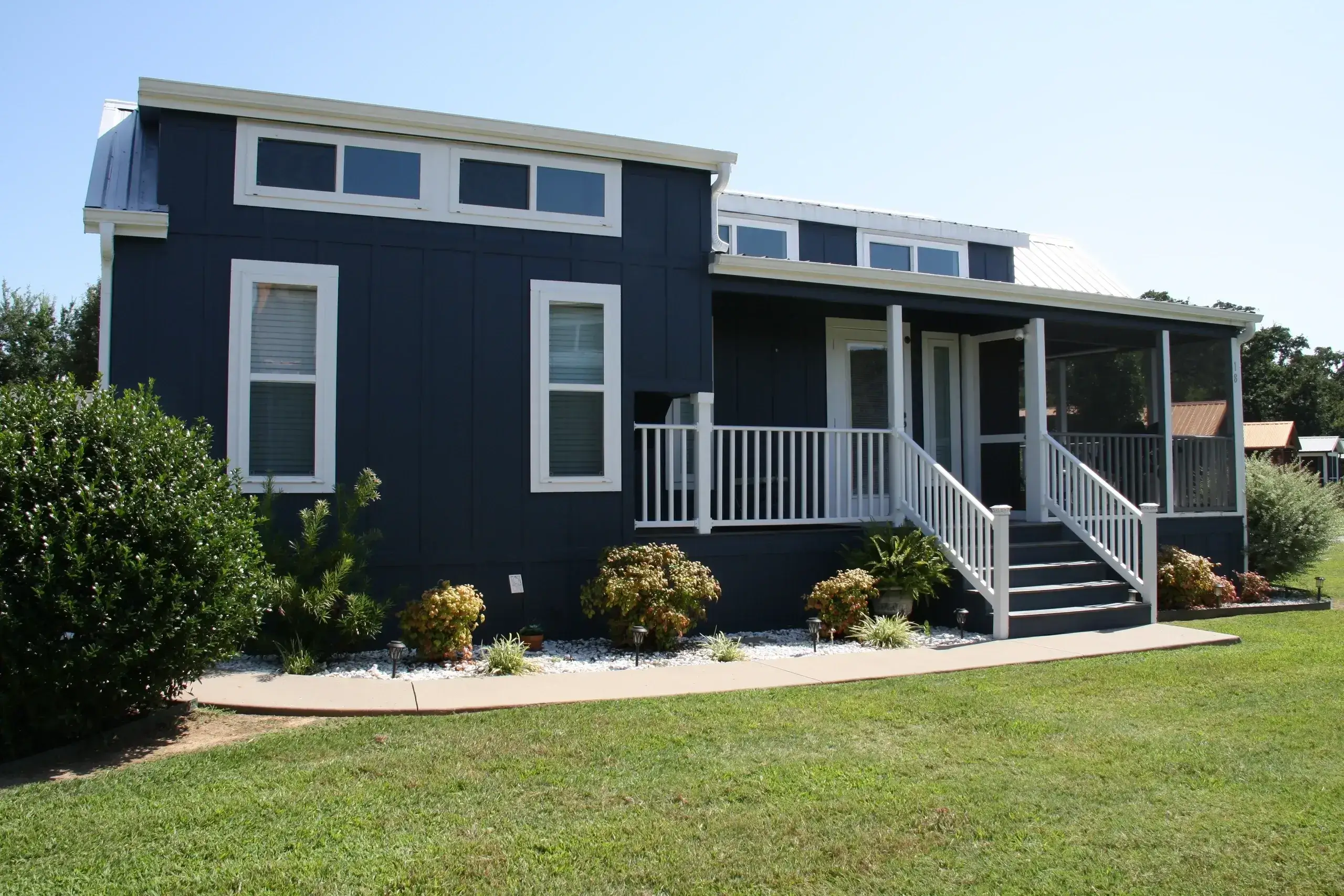 Modern blue house with white porch railing.
