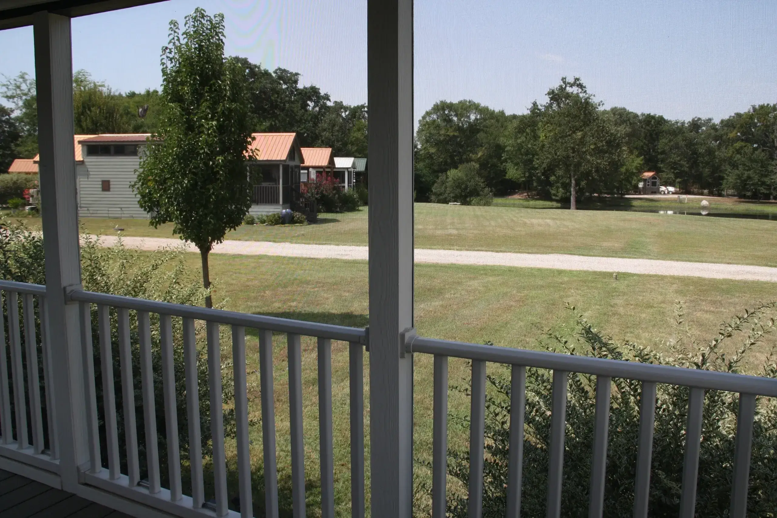 Porch view of houses and green landscape.