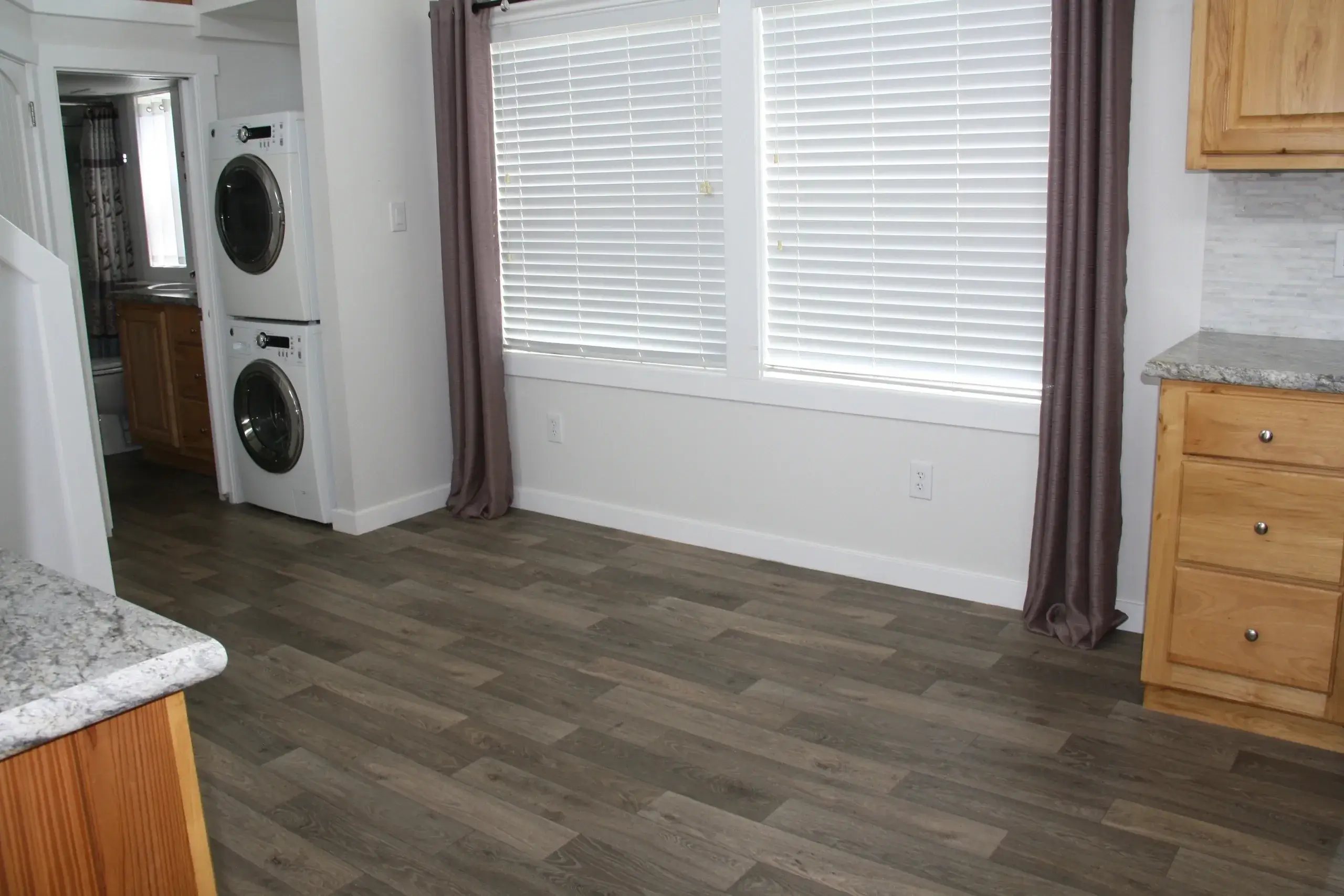 Empty room with hardwood floor and windows.