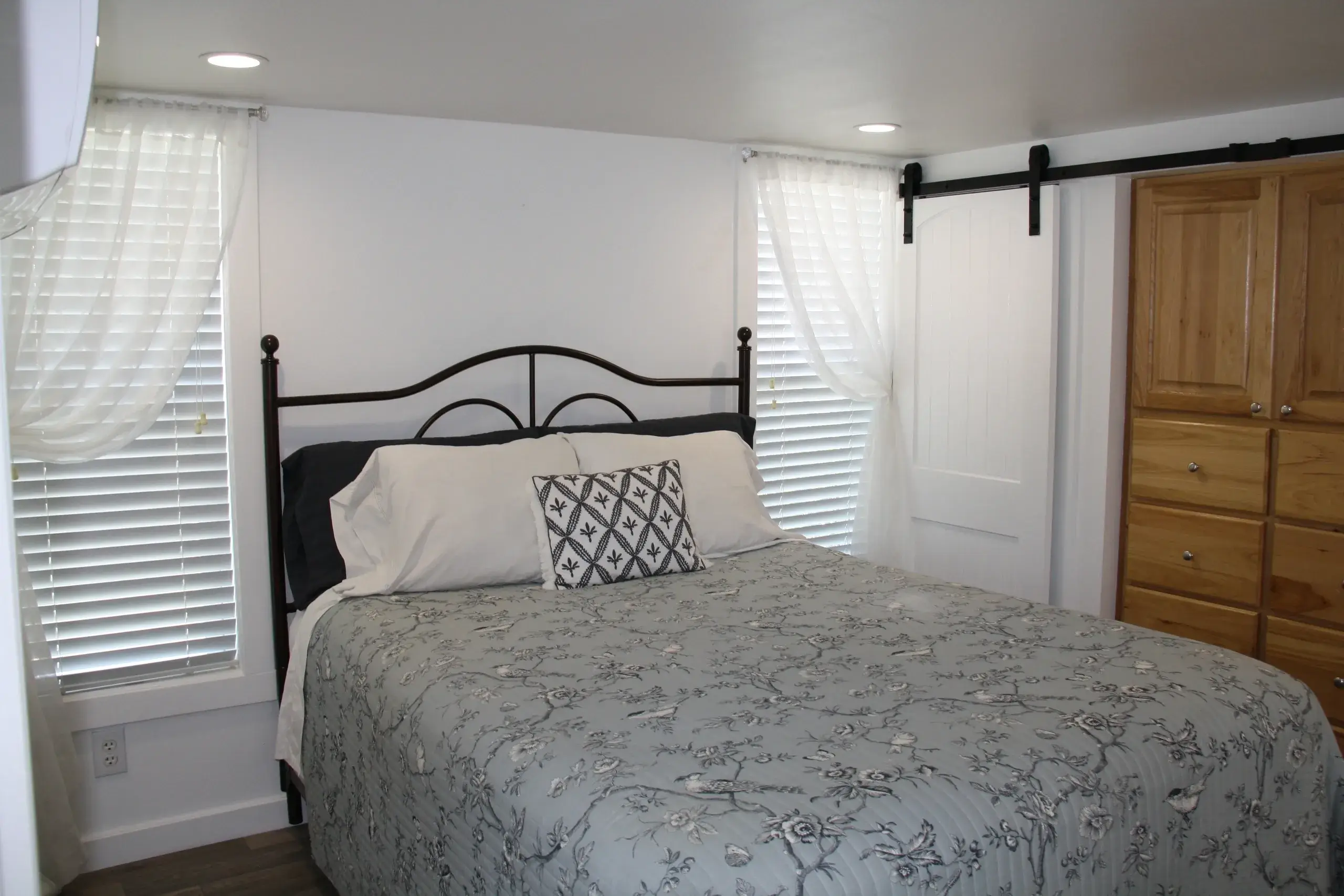 Cozy bedroom with bed and wooden dresser.