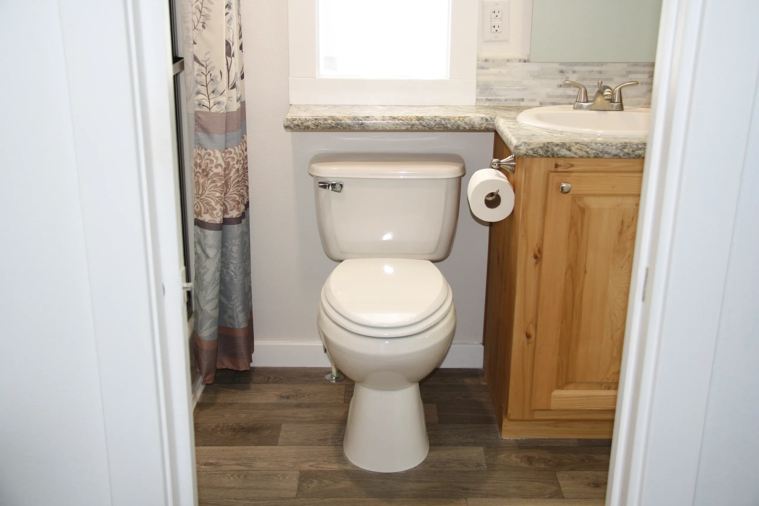 Bathroom with toilet and wooden cabinet.
