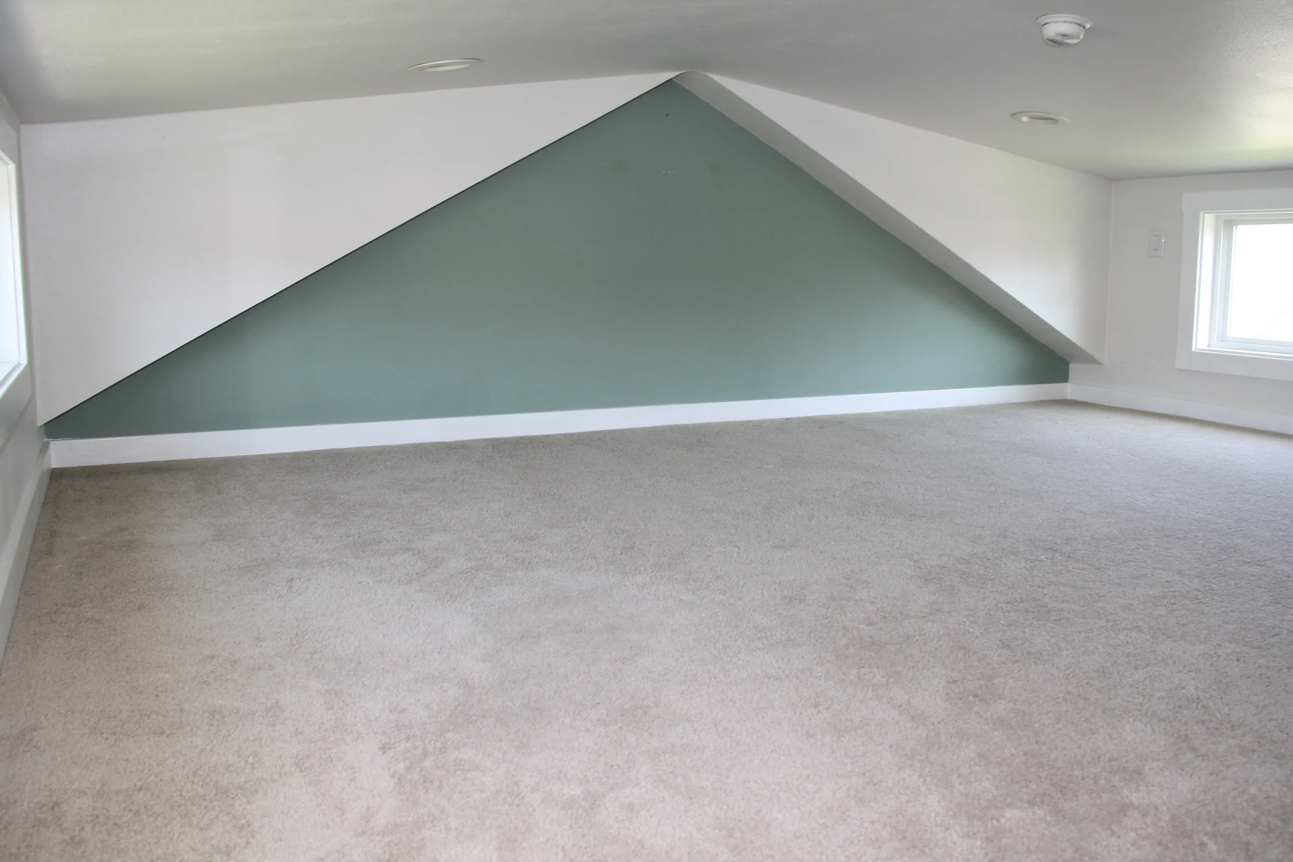 Empty attic room with triangular wall.