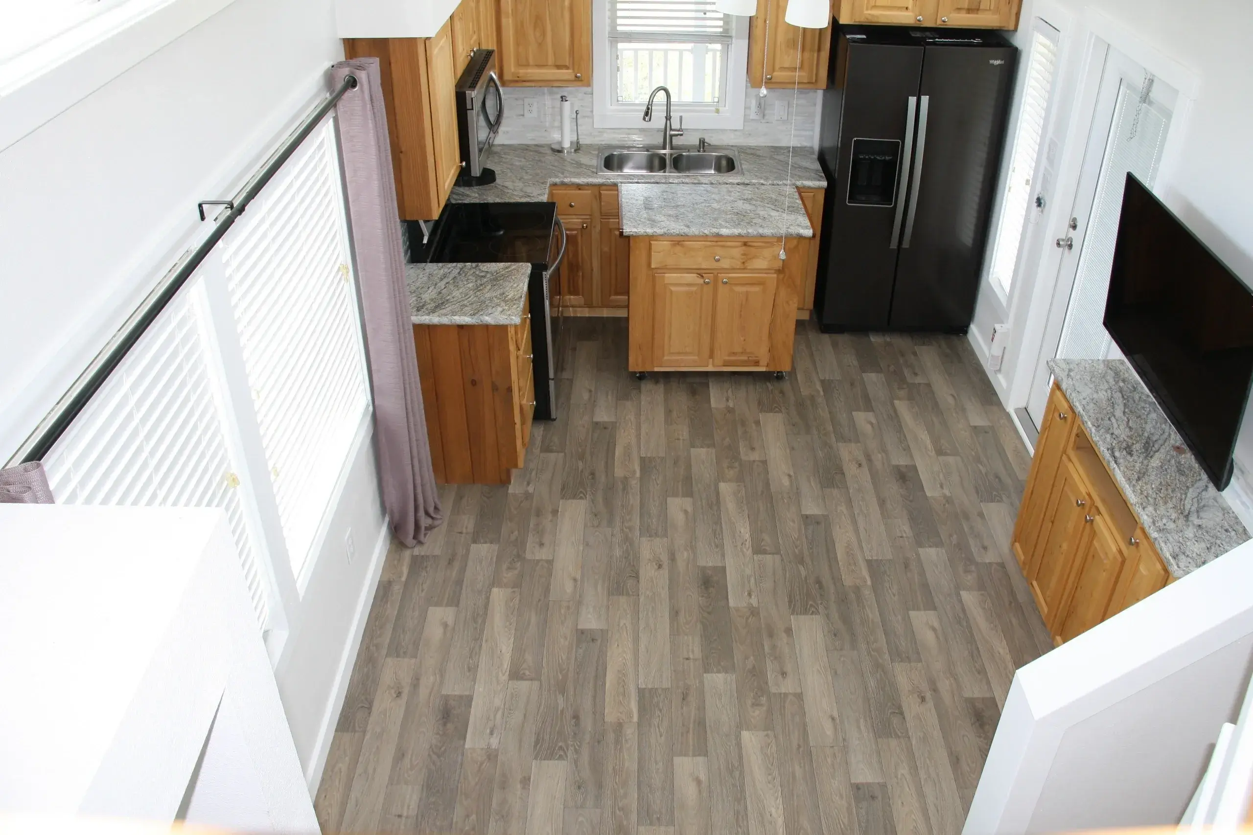 Modern kitchen with wooden cabinets and flooring.