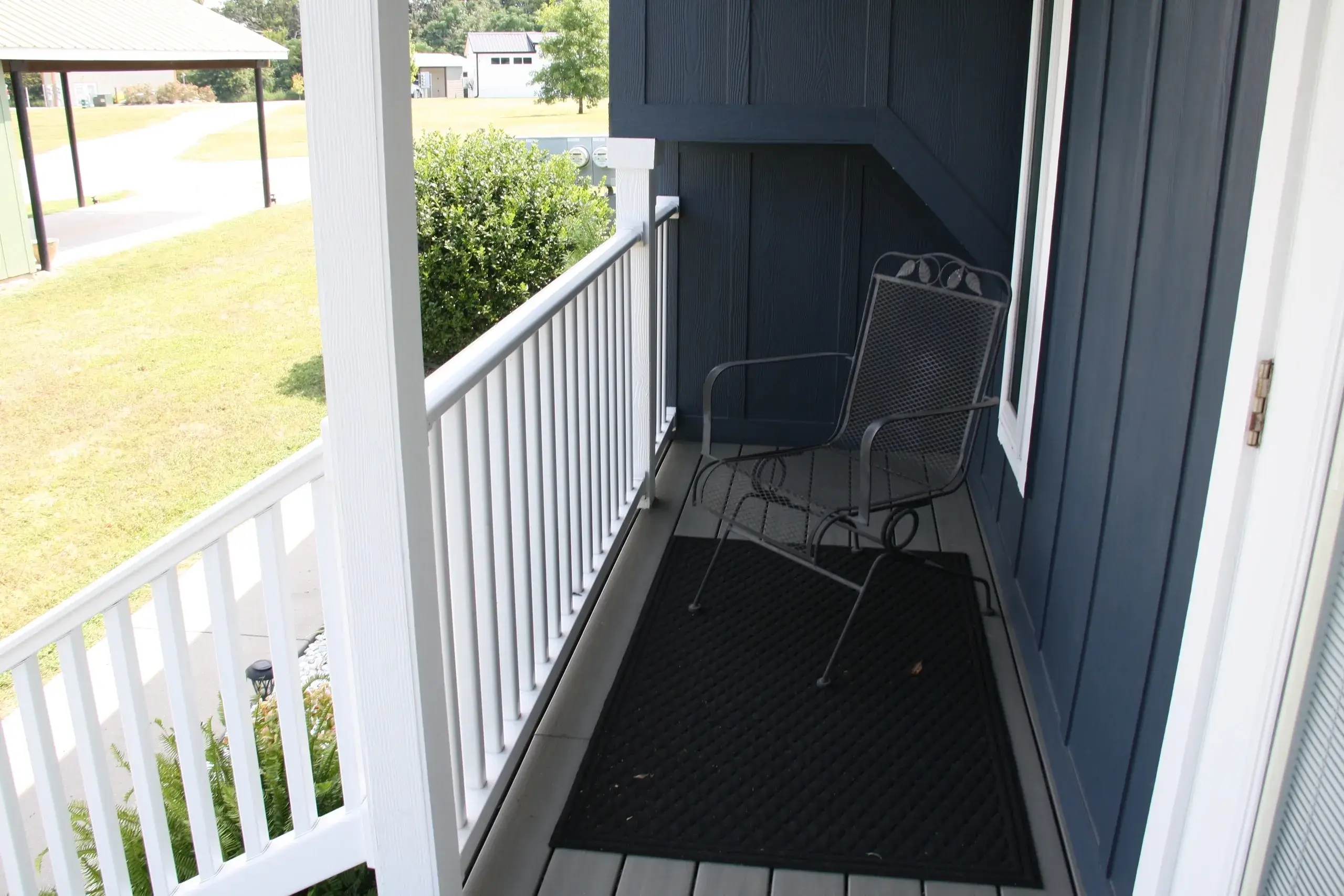 Small porch with a metal chair outside.