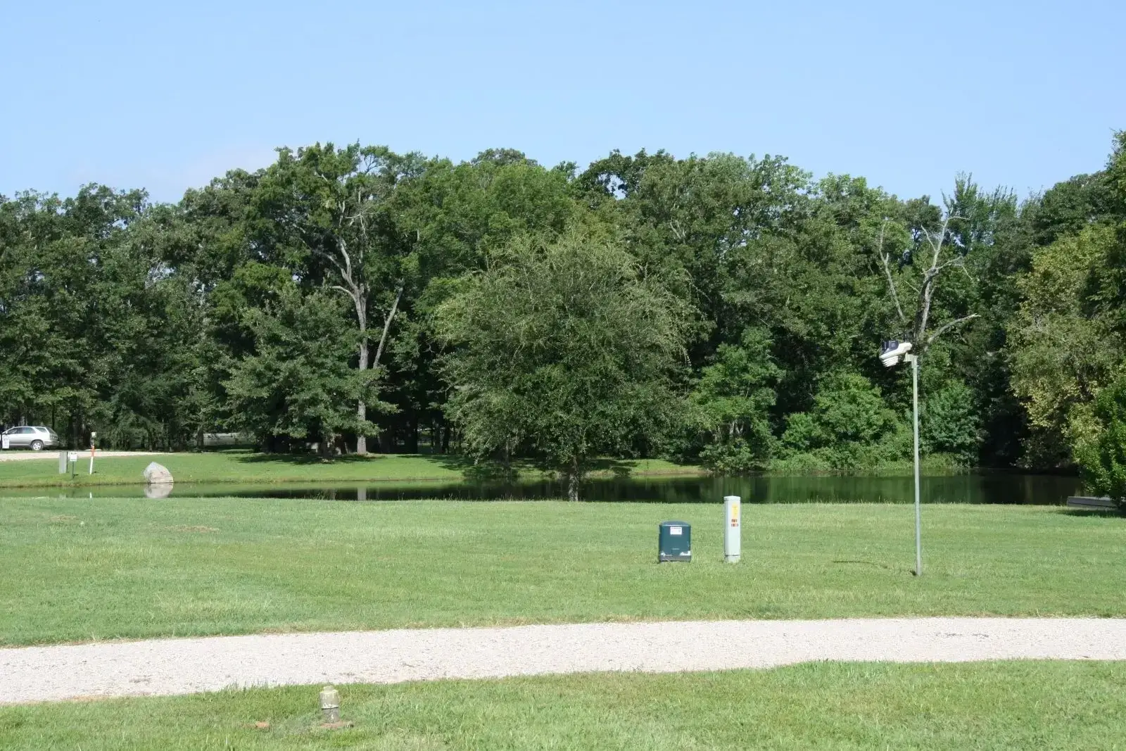 Grassy park with pond and treeline